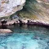 Qui la roccia con sfumature che vanno dal verdone al viola si riflette sull�acqua cristallina e limpidissima